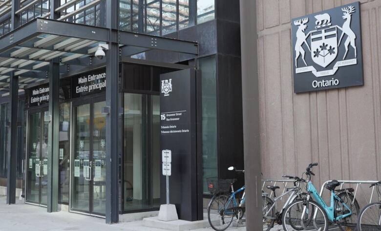 The black stone faade, sign and glass entry doors for the Ontario Landlord and Tenant Board office in Toronto.