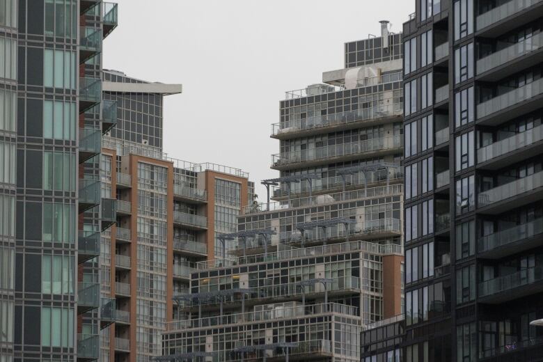 Image of several tall apartment buildings in a neighbourhood.