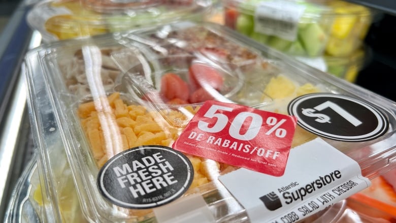 A cobb salad in a plastic container. A red 50% off sticker can be seen next to a sticker advertising a price of $7.