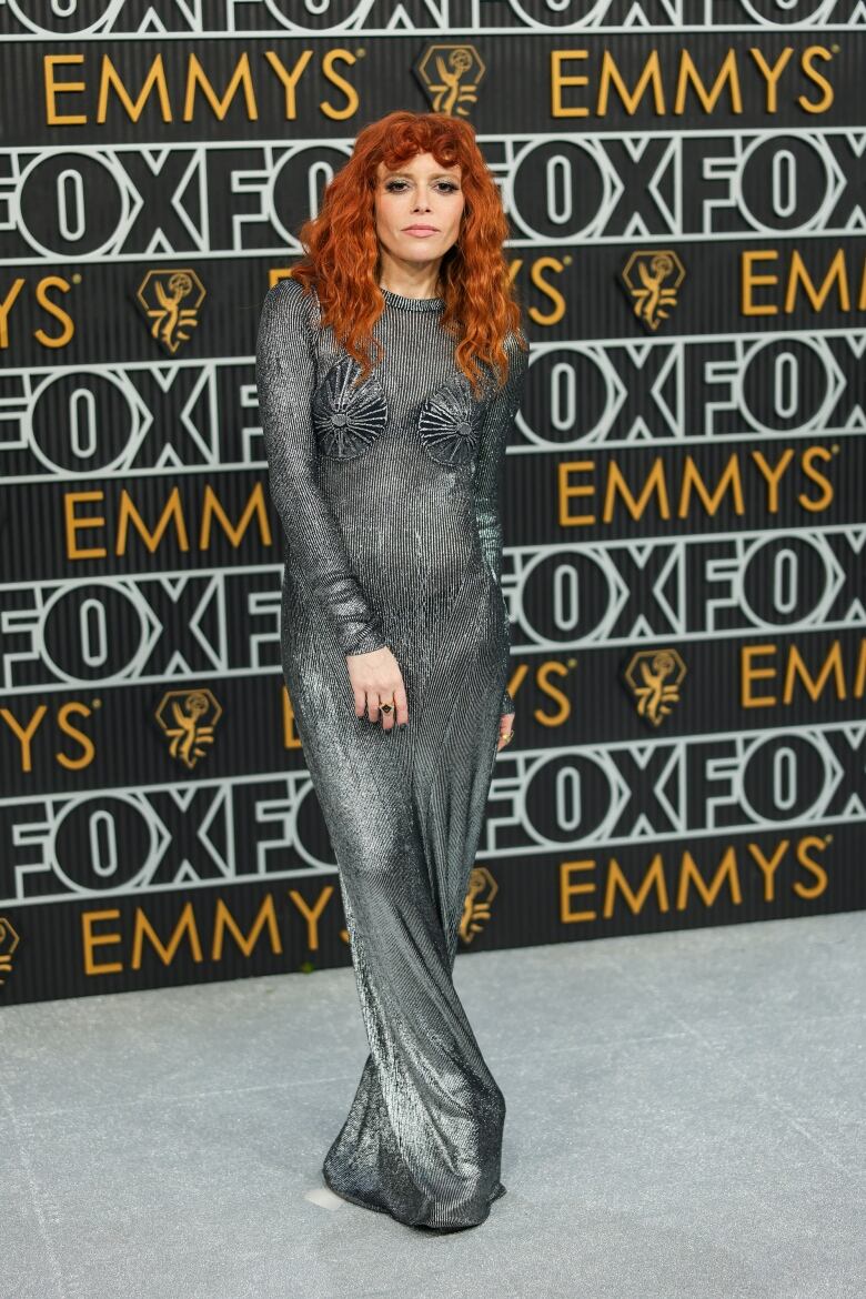 Natasha Lyonne on the Emmys red carpet wearing a silver, metallic floor-length gown.