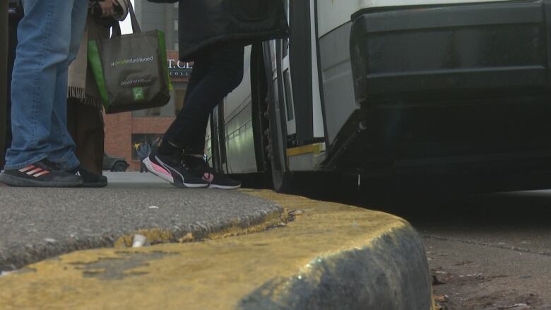 A close-up of feet of passengers on a bus.