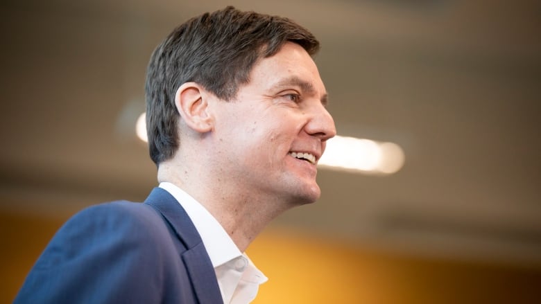 David Eby is pictured in profile, smiling, from the shoulders up.