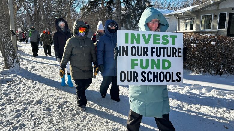 A woman holds a sign with the message 