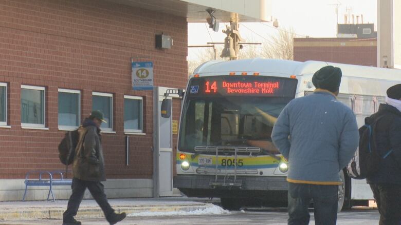 A bus at a terminal on a winter day.