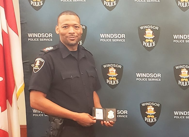 A police officer poses with his badge.