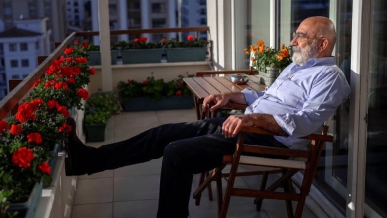 Turkish journalist and writer Ahmet Altan sits on his balcony during an interview at his home in Istanbul 