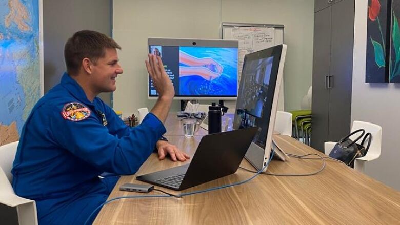 Canadian astronaut, Jeremy Hansen sits at a computer desk looking at the screen while talking to Indigenous students in remote northern communities. 