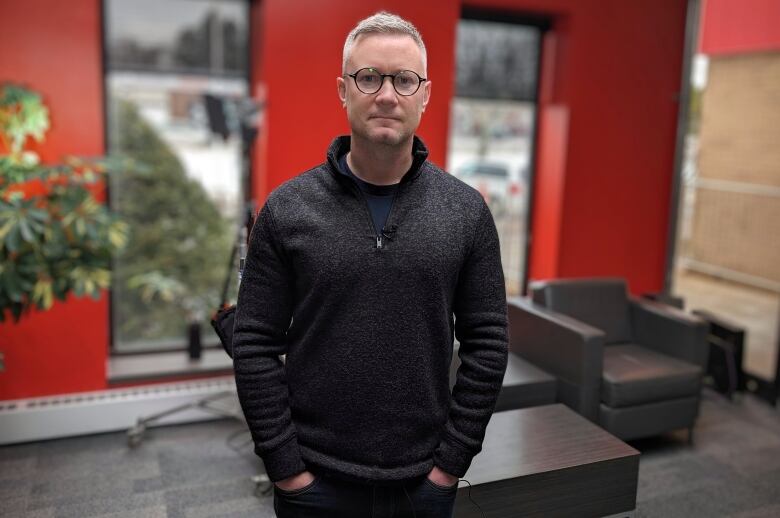 A man in a dark sweater stands in the CBC P.E.I. lobby. 