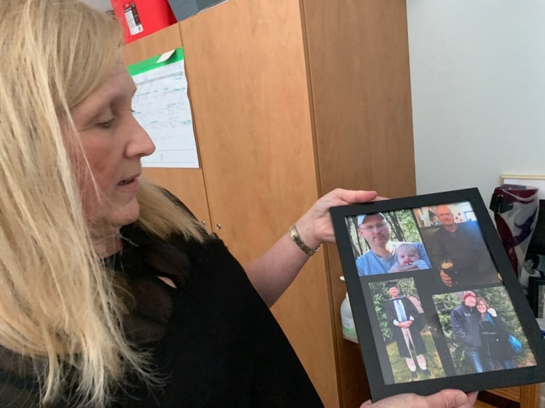 A woman shows holds a picture frame showing several photos.