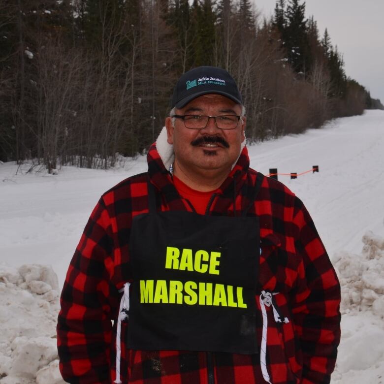 Man in flannel with bib that reads 