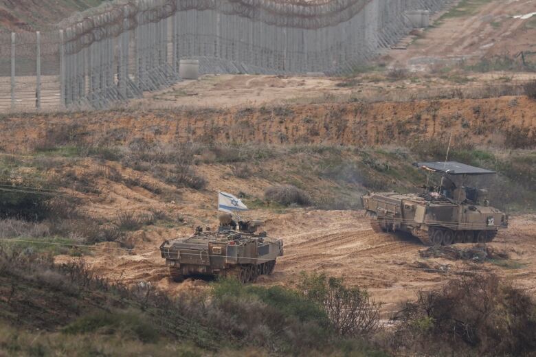 Israeli military vehicles gather, amid the ongoing conflict between Israel and the Palestinian Islamist group Hamas, near the Israel-Gaza border, in southern Israel, January 14, 2024. 