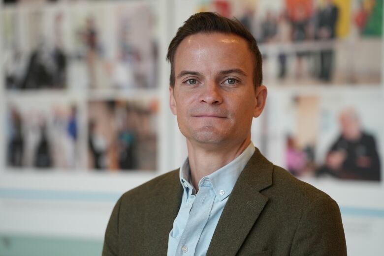 Man standing in collared shirt and suit.