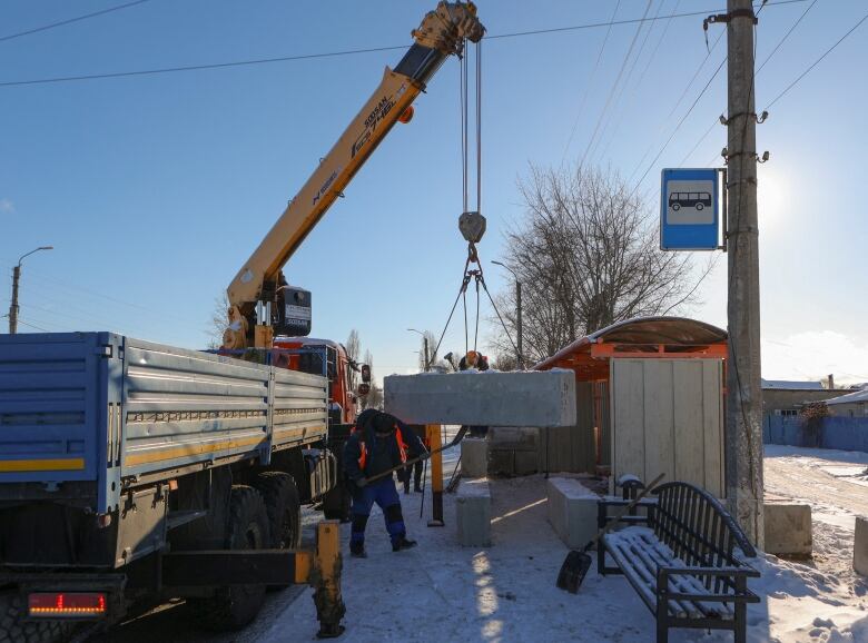 Workers are seen installing protective concrete blocks at a bus stop in Belgorod, Russia, in January 2024.