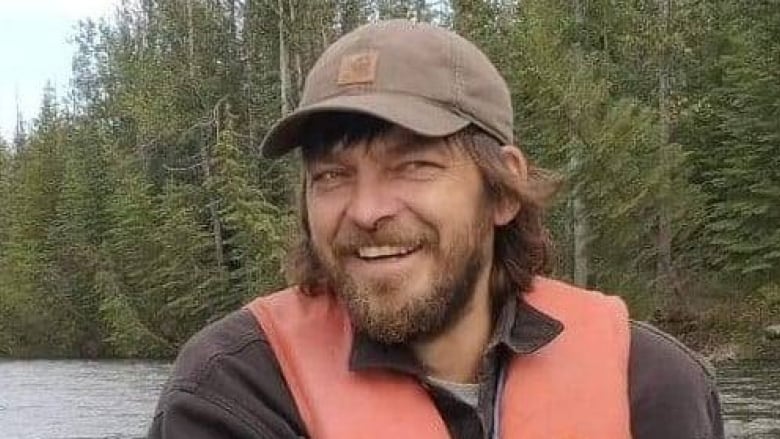 A smiling man wearing a life jacket in a boat.