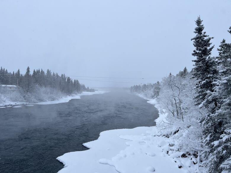 Looking down a partially ice-covered river in winter.