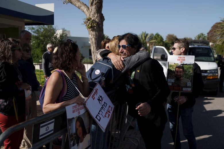 Two people embrace during a protest.