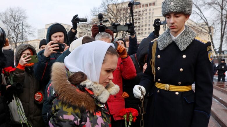 Maria Andreyeva, the wife of a Russia soldier sent to Ukraine, is seen laying flower at the Tomb of the Unknown Soldier in Moscow.