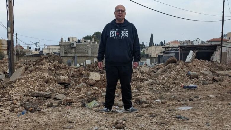 A man stands in a pile of rubble.