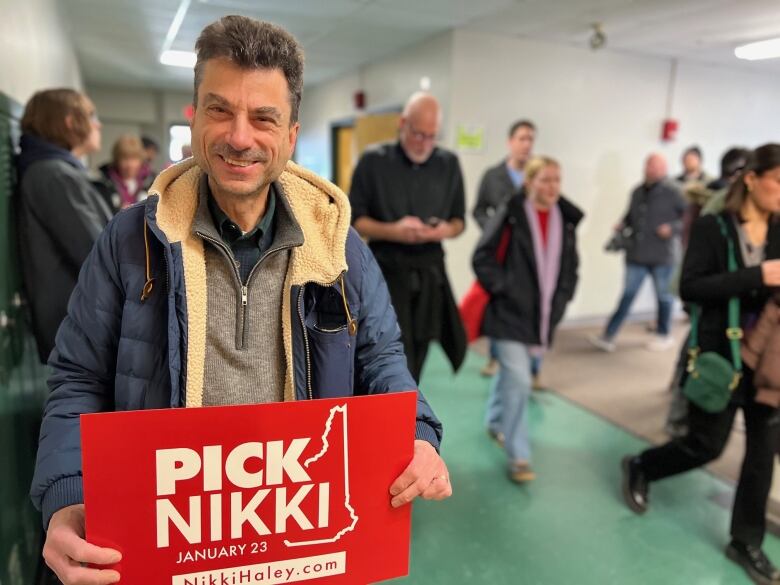 Man holds sign that says Pick Nikki