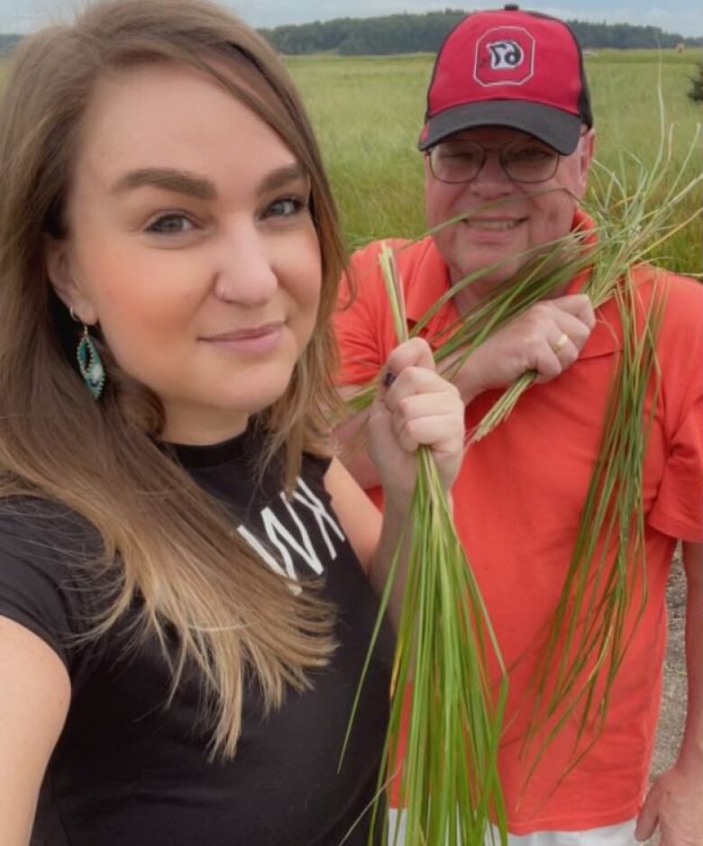 An Indigenous pair harvesting sweetgrass together. 