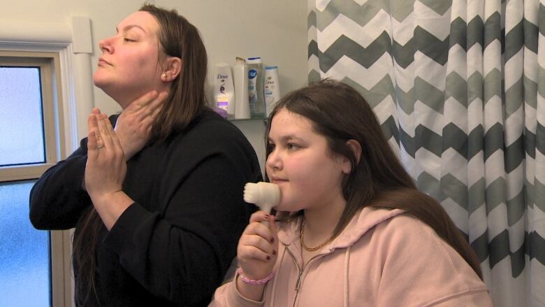 A mother and daughter wash their faces.