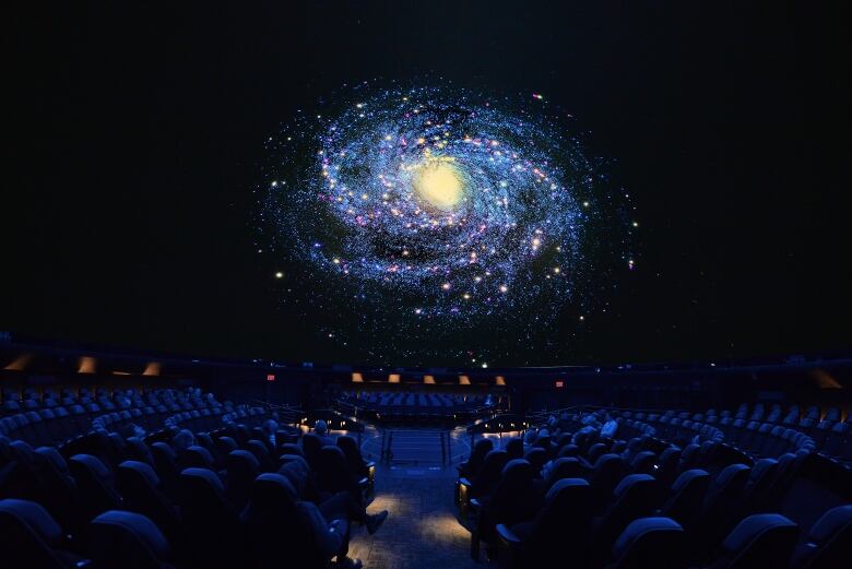 Audience watching space show in the Hayden Planetarium.