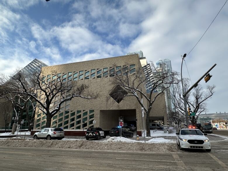 Four police vehicles outside a large building.