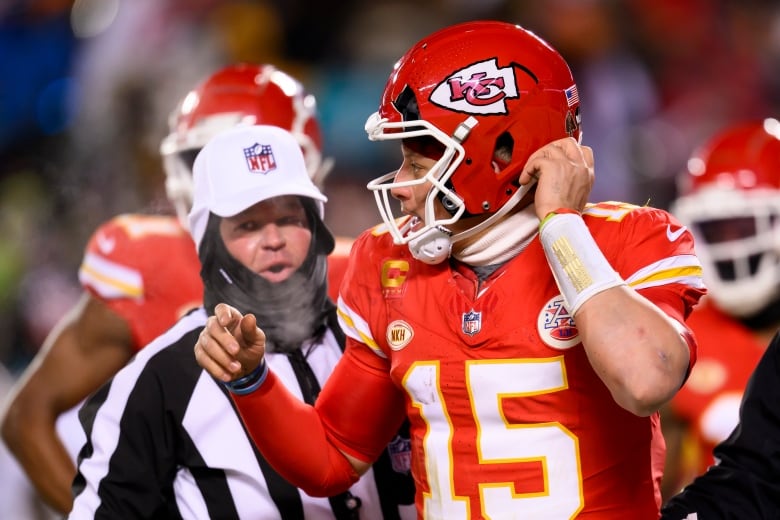 Kansas City Chiefs quarterback Patrick Mahomes heads to the bench to get his helmet replaced after part of it was broken off.