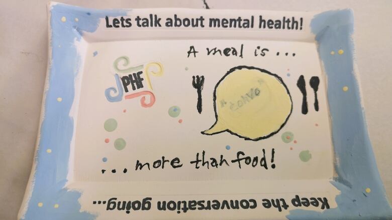 A square plate with a blue border highlighting the importance of talking about mental health.