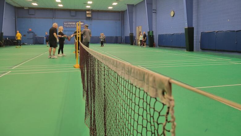 Players converge around the net on a pickleball court in Scarborough, Ont.