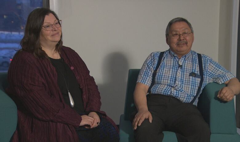 A man and woman sit side by side. 