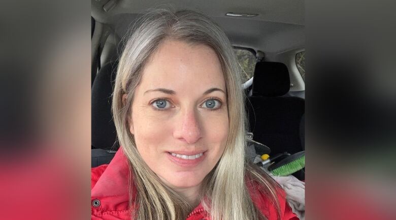 Head and shoulders picture of a smiling woman sitting in a vehicle.