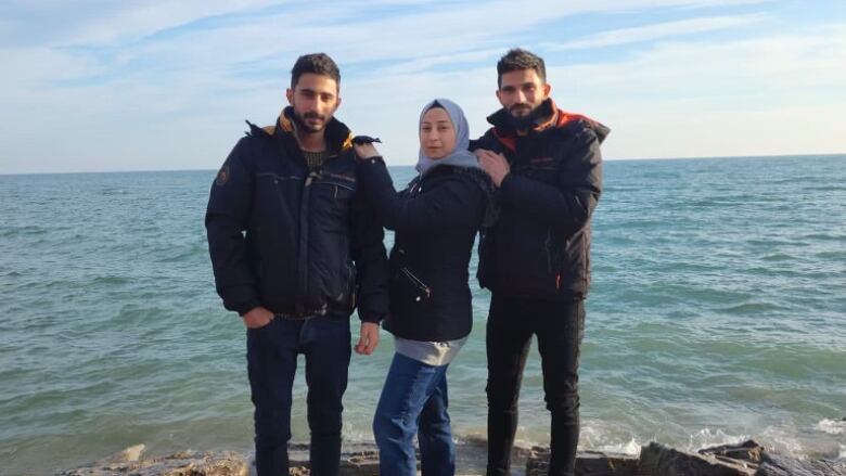 Three siblings stand on a rock