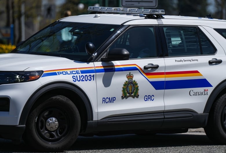 A police vehicle marked 'RCMP GRC' lies on a street.