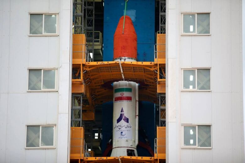 A close up view of a red and white rocket prepared for launch. 