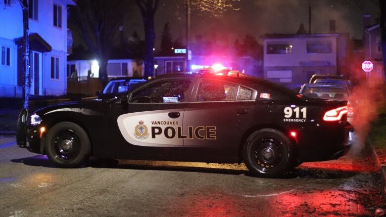 A Vancouver Police car is parked on a residential street at night. 