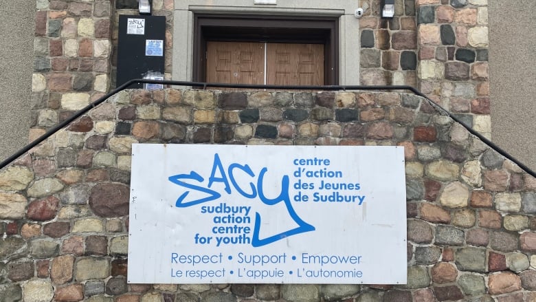 The front of a stone building with a sign that says Sudbury Action Centre for Youth.