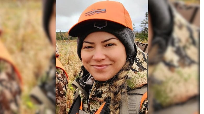 a woman wearing camouflage hunting gear.  