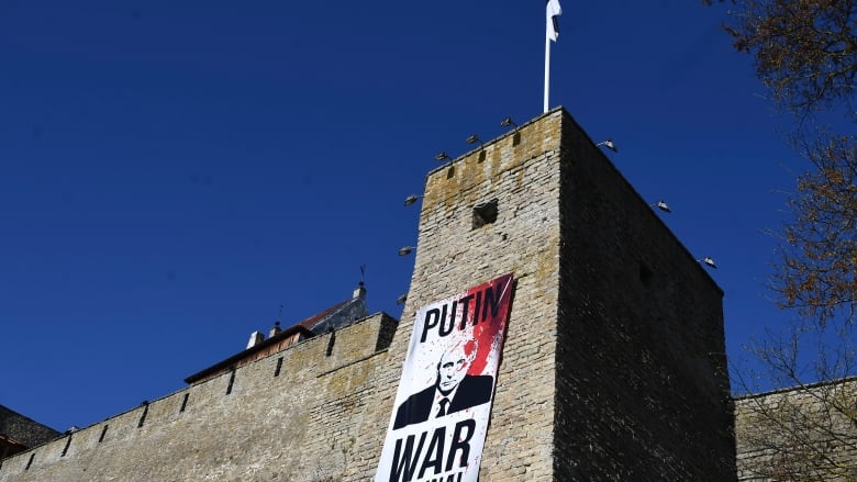 A poster is seen in on the side of a castle.