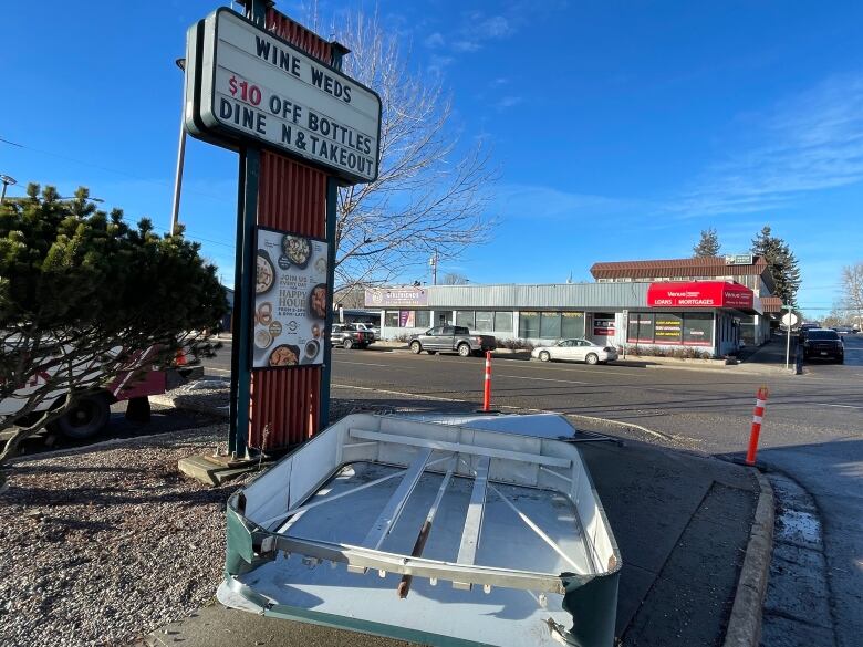 A sign collapsed on a sidewalk.