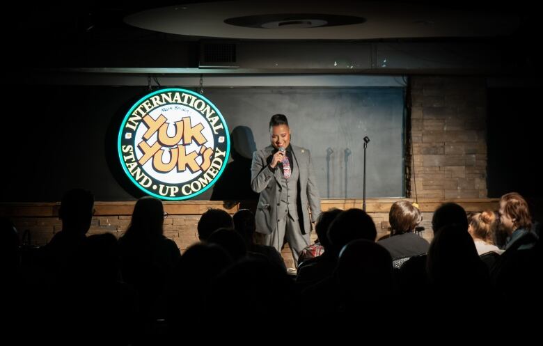 A comedian on stage with a microphone during a show.