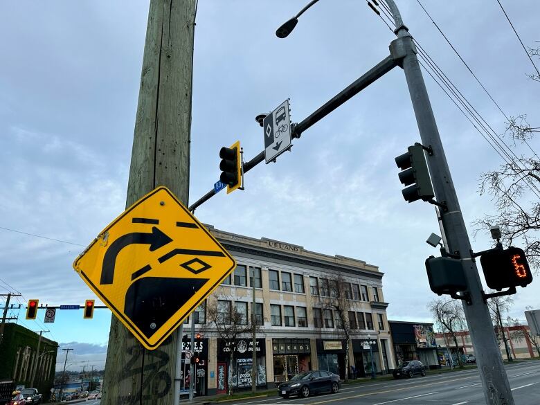 A bright yellow road sign indicates a bus lane. 