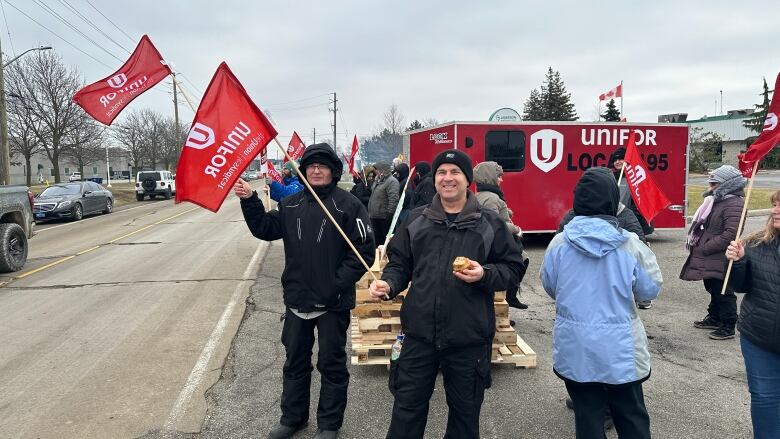 Workers hold pickets on a picket line.