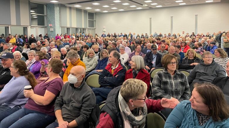 A large crowd of about 350 people filling a conference room