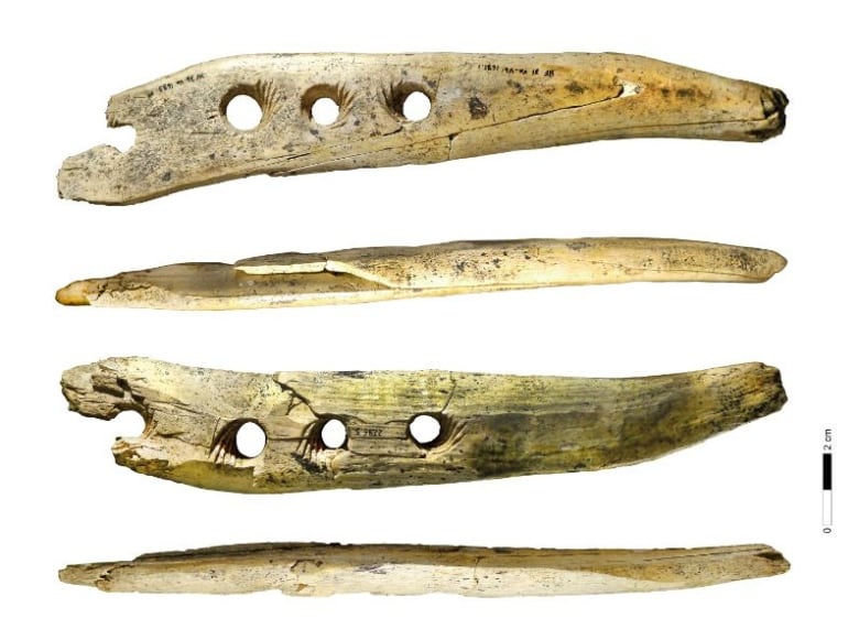 Four views of a flat piece of mammoth ivory, with three holes drilled in. 