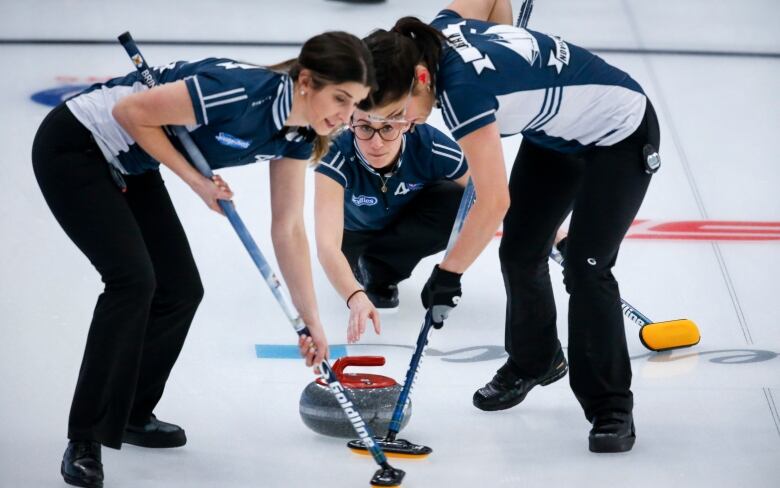 Team Nova Scotia skip Jill Brothers, centre, makes a shot against Team Northern Ontario as second Jennifer Brine, left, and lead Emma Logan sweep at the Scotties Tournament of Hearts in Calgary on Wednesday, Feb. 24, 2021.