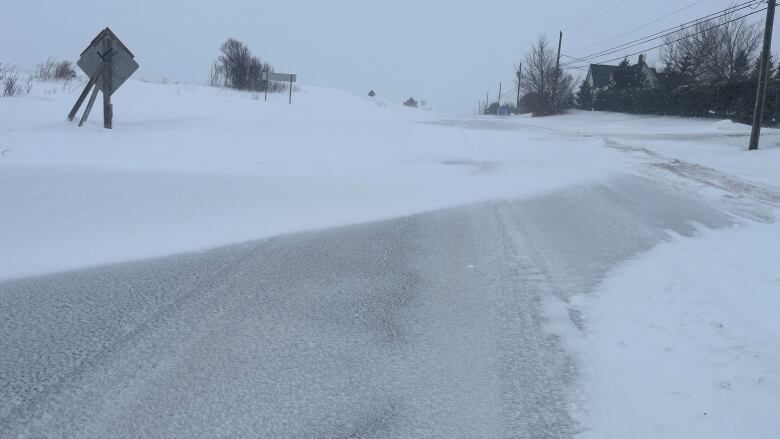 A highway with deep snow drifts across it.