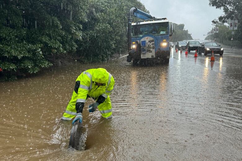 A man stands on a flooded street.