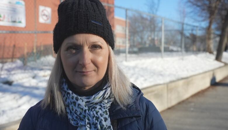 A school's vice-principal gives an interview outside in winter.