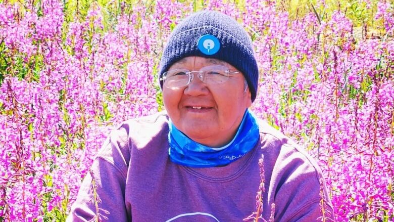 A woman wearing a purple shirt that says 